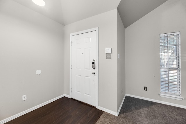 foyer entrance featuring vaulted ceiling, dark hardwood / wood-style floors, and plenty of natural light