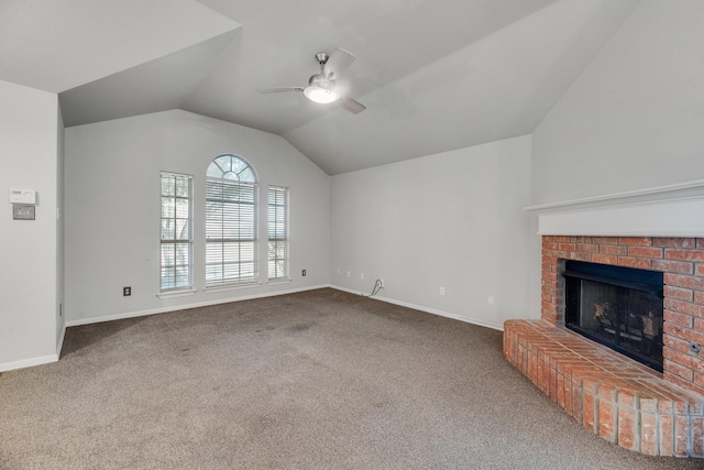 unfurnished living room featuring ceiling fan, a brick fireplace, vaulted ceiling, and carpet