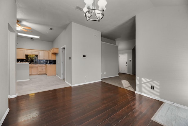 unfurnished living room with wood-type flooring, lofted ceiling, and ceiling fan with notable chandelier