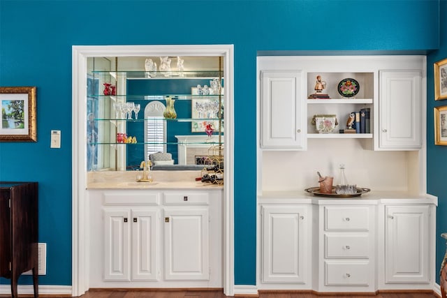 bar featuring sink and white cabinets