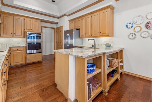 kitchen with sink, dark hardwood / wood-style flooring, light stone counters, kitchen peninsula, and stainless steel appliances