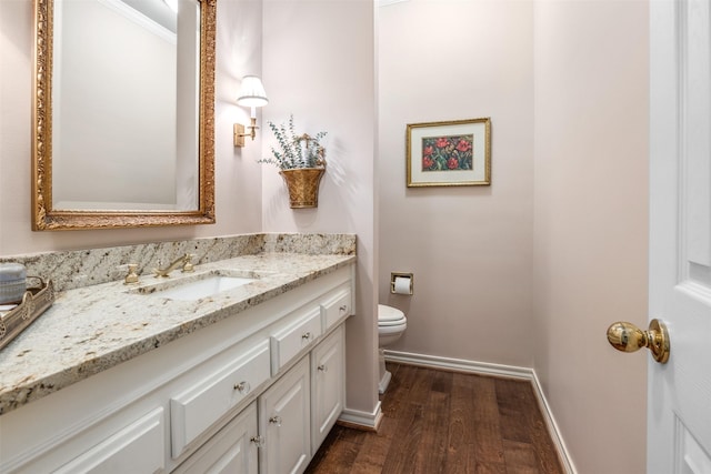 bathroom featuring wood-type flooring, toilet, and vanity