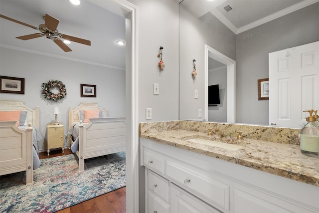 bathroom featuring ornamental molding, hardwood / wood-style floors, vanity, and ceiling fan