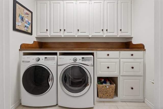 clothes washing area featuring cabinets, light tile patterned flooring, and independent washer and dryer