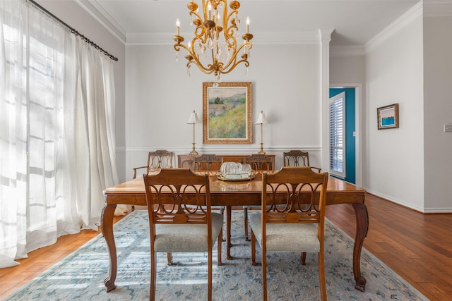 dining space featuring a notable chandelier, plenty of natural light, ornamental molding, and wood-type flooring