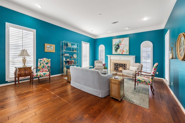 living room with crown molding, a premium fireplace, and hardwood / wood-style floors