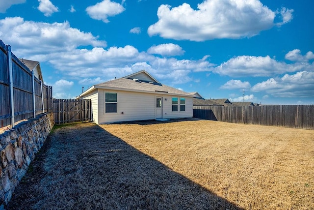 rear view of property featuring a yard