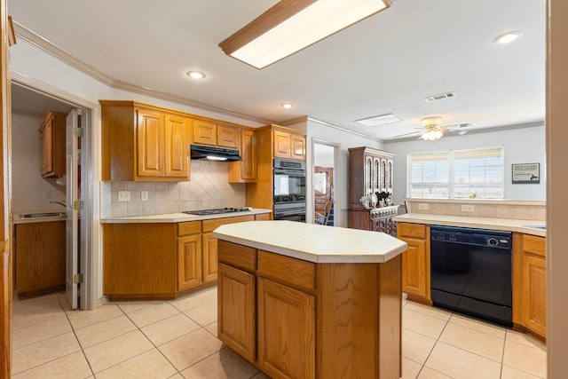 kitchen with light tile patterned flooring, crown molding, black appliances, a center island, and backsplash