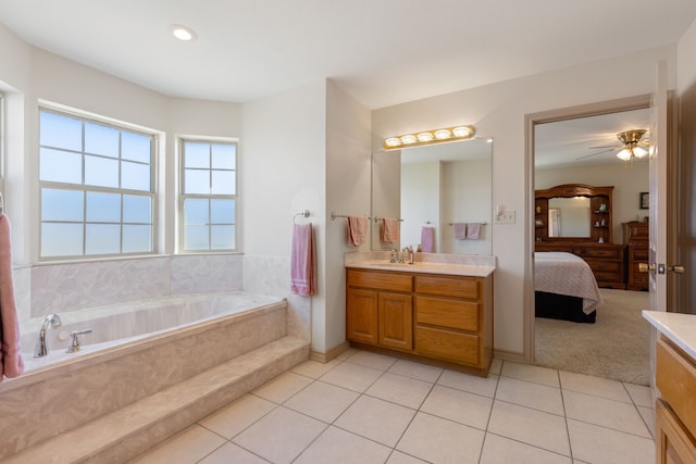 bathroom featuring vanity, tile patterned flooring, and tiled tub