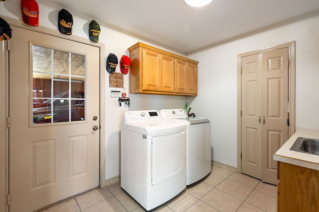 laundry area with light tile patterned flooring, cabinets, and washer and dryer