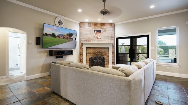 living room featuring crown molding and a brick fireplace