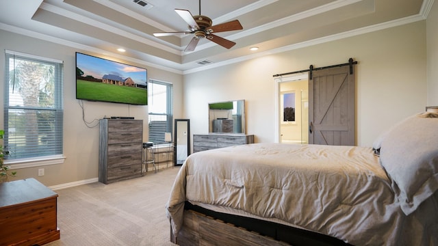 carpeted bedroom featuring a raised ceiling, a barn door, ceiling fan, and multiple windows