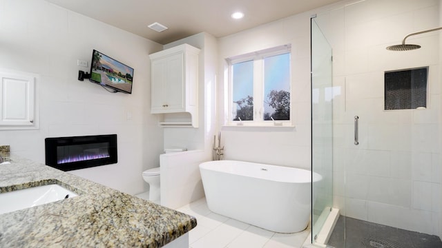 full bathroom featuring vanity, separate shower and tub, and toilet