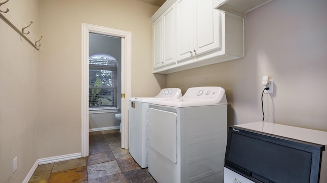 washroom with washer and dryer and cabinets