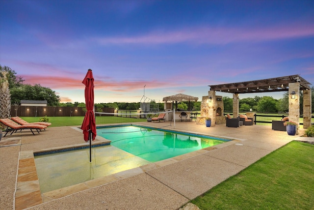 pool at dusk with a gazebo, a yard, an outdoor living space with a fireplace, and a patio