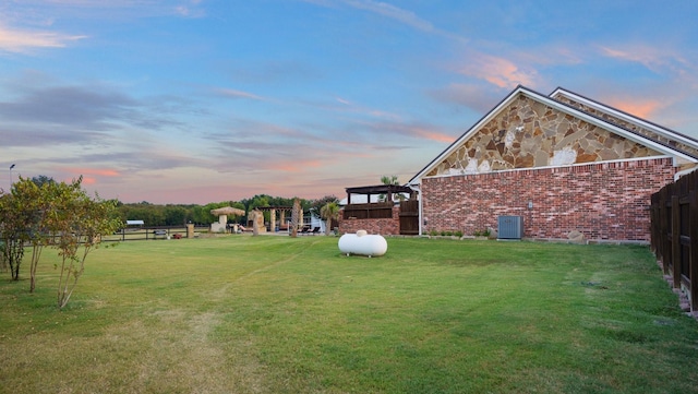 yard at dusk featuring a gazebo and central air condition unit