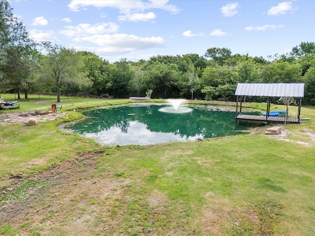 view of swimming pool with a yard and a water view