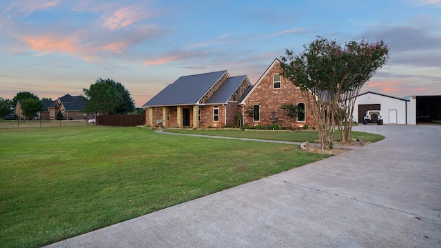 view of front facade with a garage, an outdoor structure, and a lawn