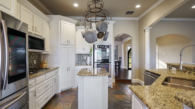 kitchen with sink, white cabinets, a center island, stainless steel appliances, and light stone countertops