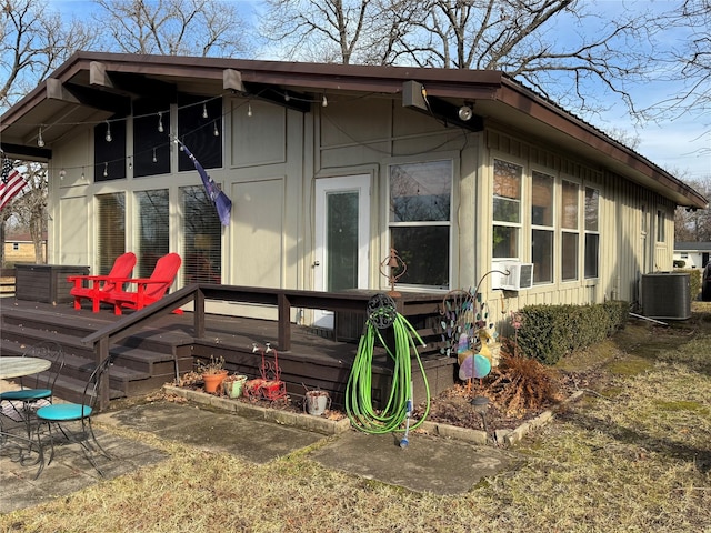 rear view of house with cooling unit and a wooden deck