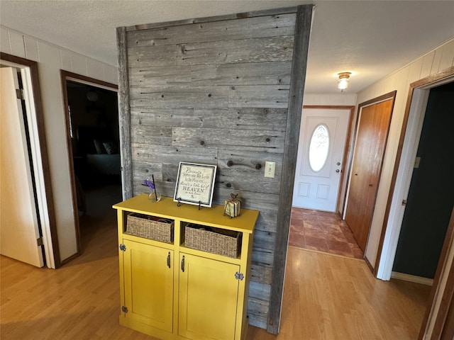 interior space featuring light wood-type flooring and wooden walls