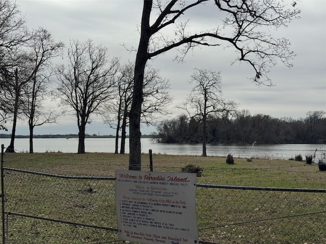 view of yard with a water view and fence