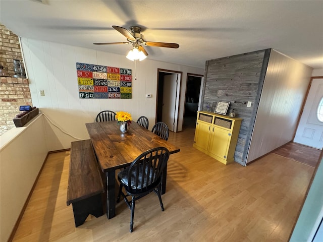 dining room with light wood finished floors and a ceiling fan