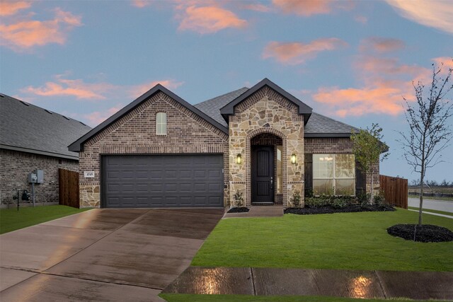 view of front of property featuring a garage and a yard