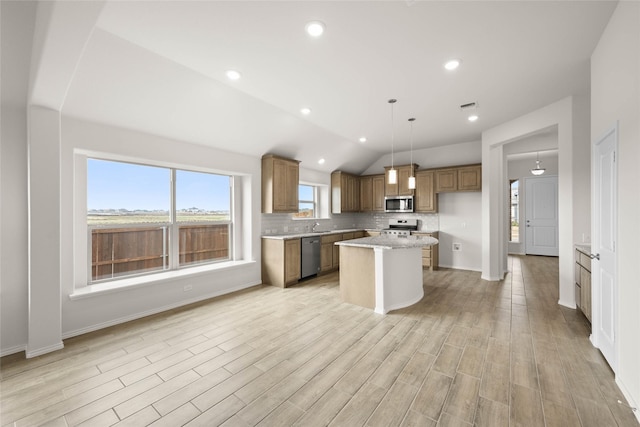 kitchen with vaulted ceiling, a kitchen island, pendant lighting, backsplash, and stainless steel appliances