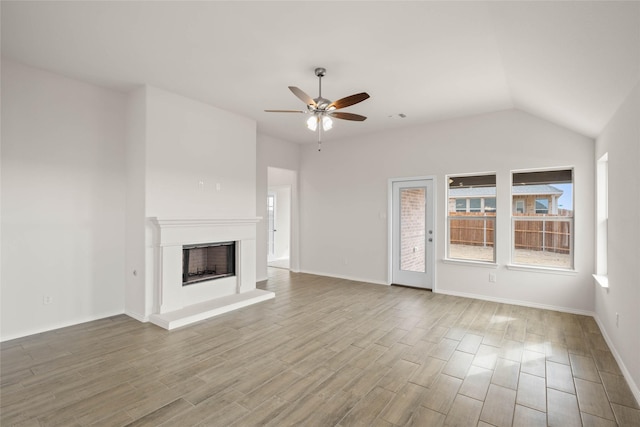 unfurnished living room featuring lofted ceiling, hardwood / wood-style floors, and ceiling fan