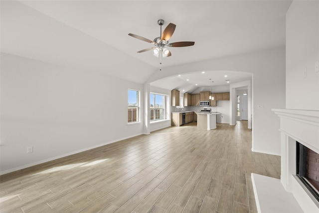 unfurnished living room featuring vaulted ceiling, ceiling fan, and light hardwood / wood-style floors