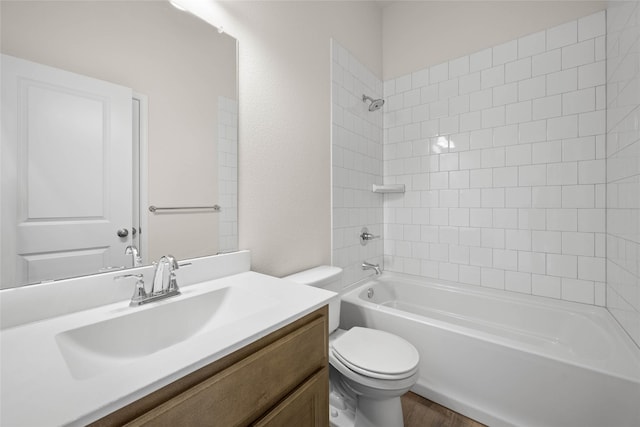 full bathroom featuring vanity, wood-type flooring, tiled shower / bath, and toilet