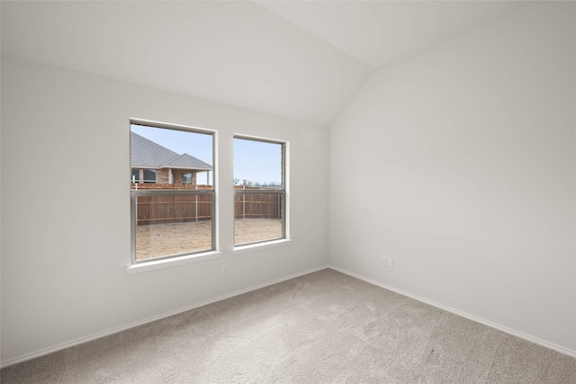 unfurnished room featuring carpet floors and vaulted ceiling