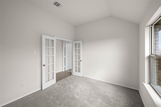 unfurnished room with lofted ceiling, carpet floors, and french doors