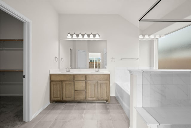 bathroom with a tub to relax in, lofted ceiling, tile patterned floors, and vanity