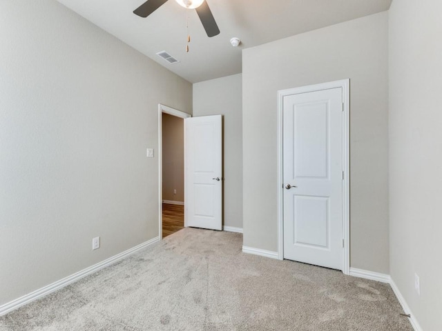 unfurnished bedroom featuring light colored carpet and ceiling fan