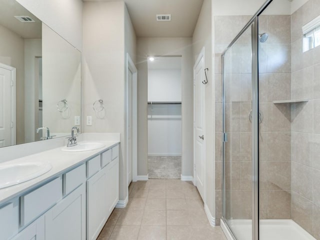 bathroom with an enclosed shower, vanity, and tile patterned floors