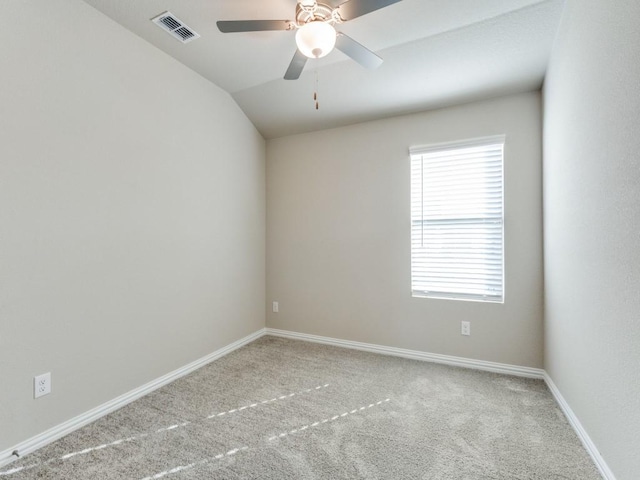 carpeted empty room with vaulted ceiling and ceiling fan