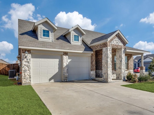 view of front of property featuring cooling unit, a garage, and a front yard