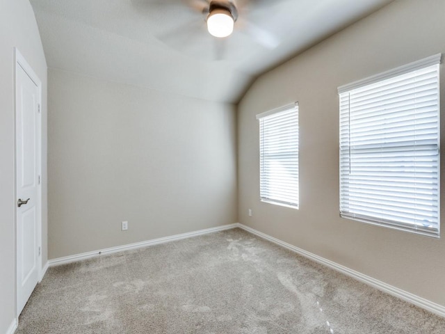 carpeted empty room featuring ceiling fan and vaulted ceiling