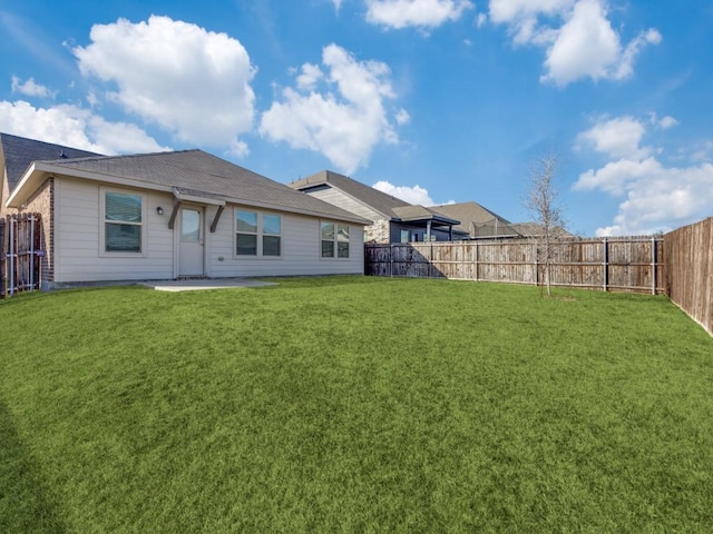 rear view of house with a yard and a patio