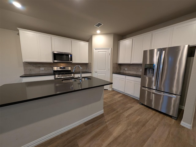 kitchen featuring white cabinetry, sink, hardwood / wood-style floors, and appliances with stainless steel finishes