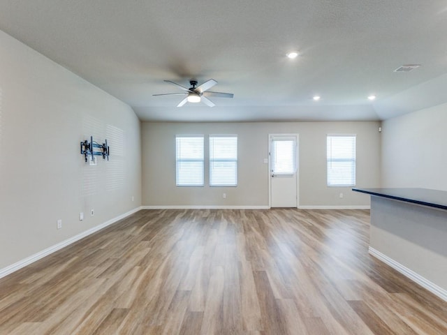 unfurnished living room with ceiling fan and light wood-type flooring