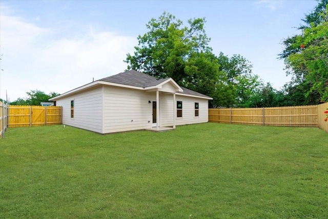 rear view of house featuring a yard