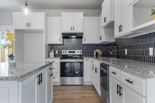 kitchen with stainless steel electric range oven, decorative light fixtures, sink, white cabinets, and exhaust hood