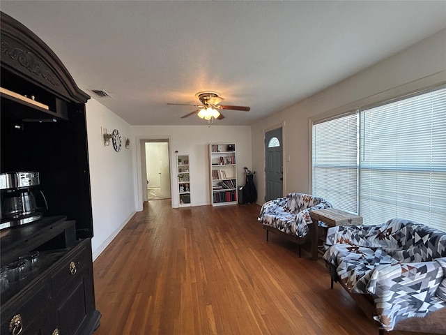 living area featuring ceiling fan and dark hardwood / wood-style floors