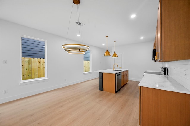 kitchen featuring sink, stainless steel dishwasher, pendant lighting, a kitchen island with sink, and stove