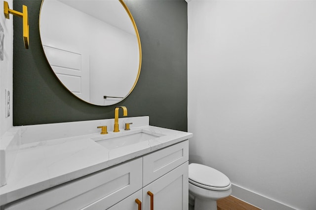 bathroom featuring hardwood / wood-style flooring, vanity, and toilet