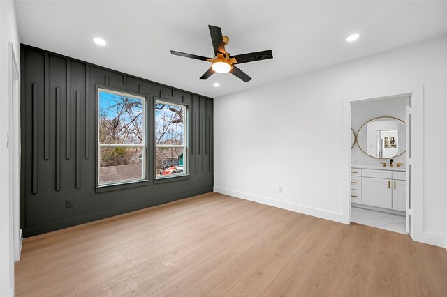 unfurnished bedroom with ensuite bathroom, ceiling fan, and light hardwood / wood-style flooring