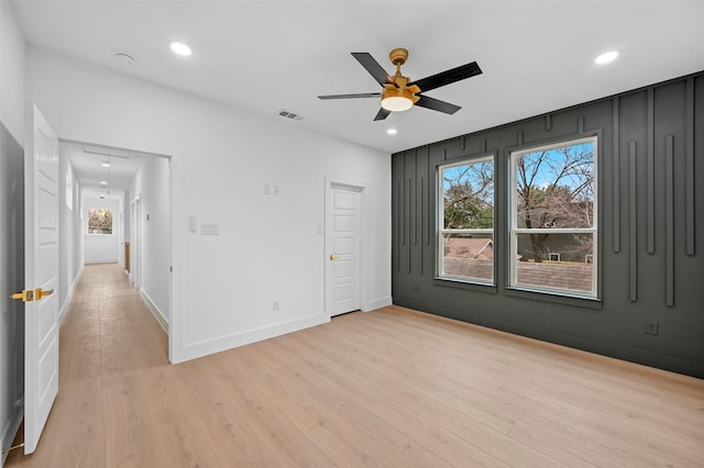 unfurnished room with ceiling fan and light hardwood / wood-style floors